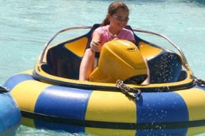 A child splashing in a yellow and blue bumper boat